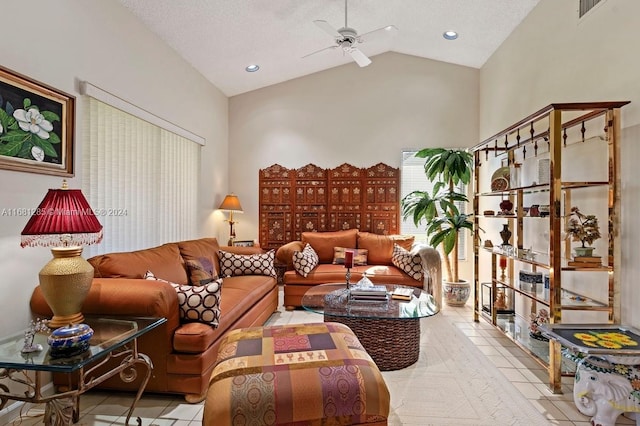 tiled living room featuring ceiling fan, a textured ceiling, and high vaulted ceiling