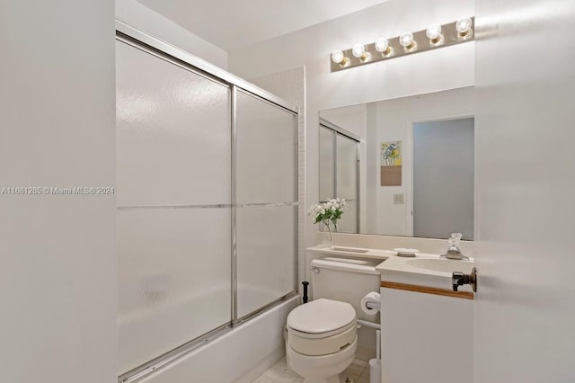 full bathroom featuring toilet, bath / shower combo with glass door, vanity, and tile patterned floors