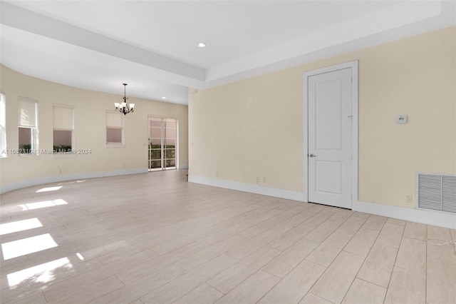 unfurnished living room with light hardwood / wood-style floors and a notable chandelier