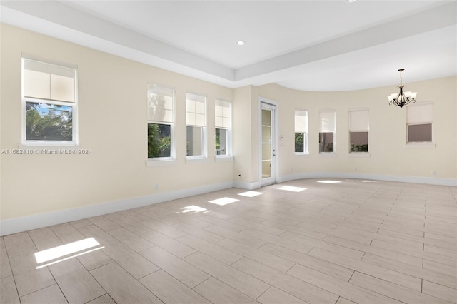 unfurnished room with a chandelier and plenty of natural light