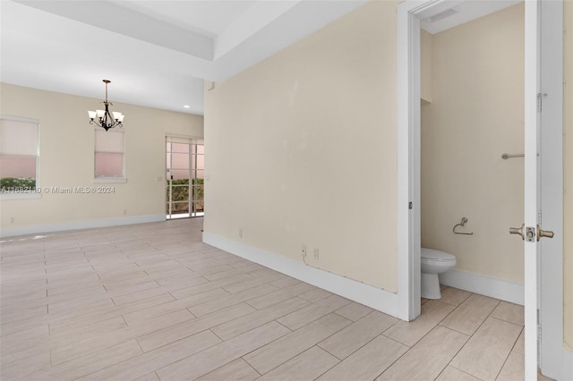 spare room featuring a chandelier