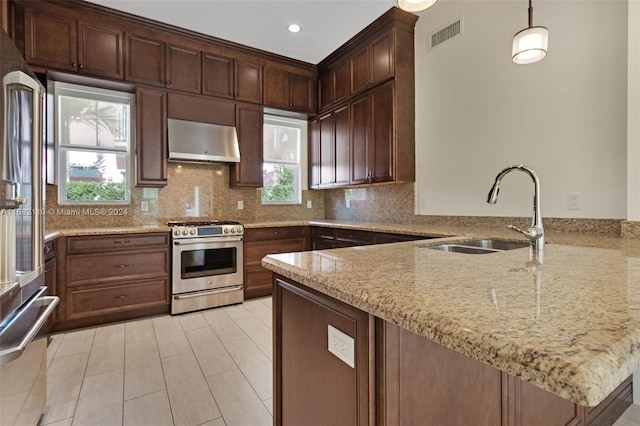 kitchen featuring sink, hanging light fixtures, stainless steel appliances, range hood, and kitchen peninsula