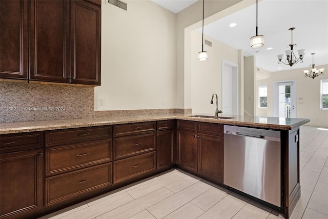 kitchen featuring dishwasher, backsplash, sink, light stone counters, and a chandelier