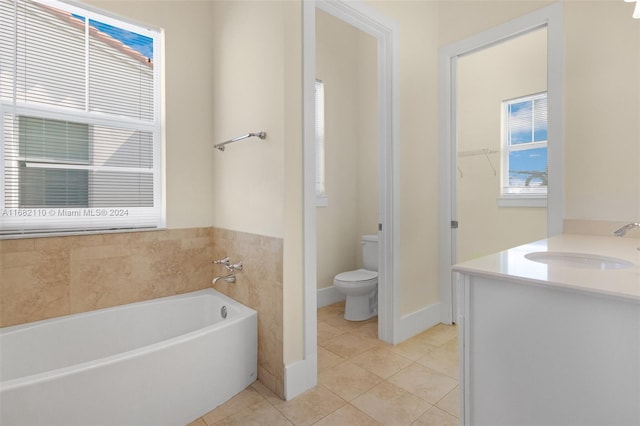 bathroom with tile patterned flooring, vanity, toilet, and a tub