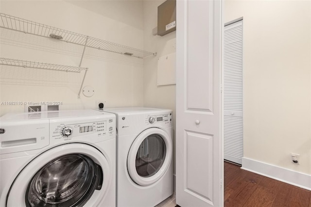 laundry room with washing machine and dryer and dark wood-type flooring