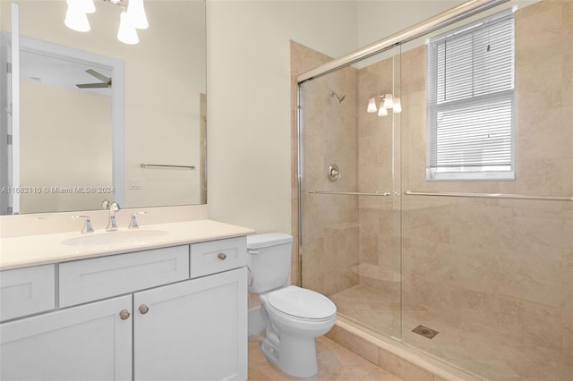 bathroom featuring tile patterned flooring, vanity, toilet, and a shower with door