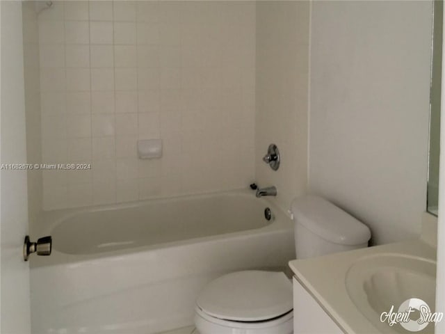 full bathroom featuring tiled shower / bath, vanity, and toilet