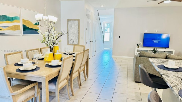 dining room featuring light tile patterned flooring and ceiling fan with notable chandelier