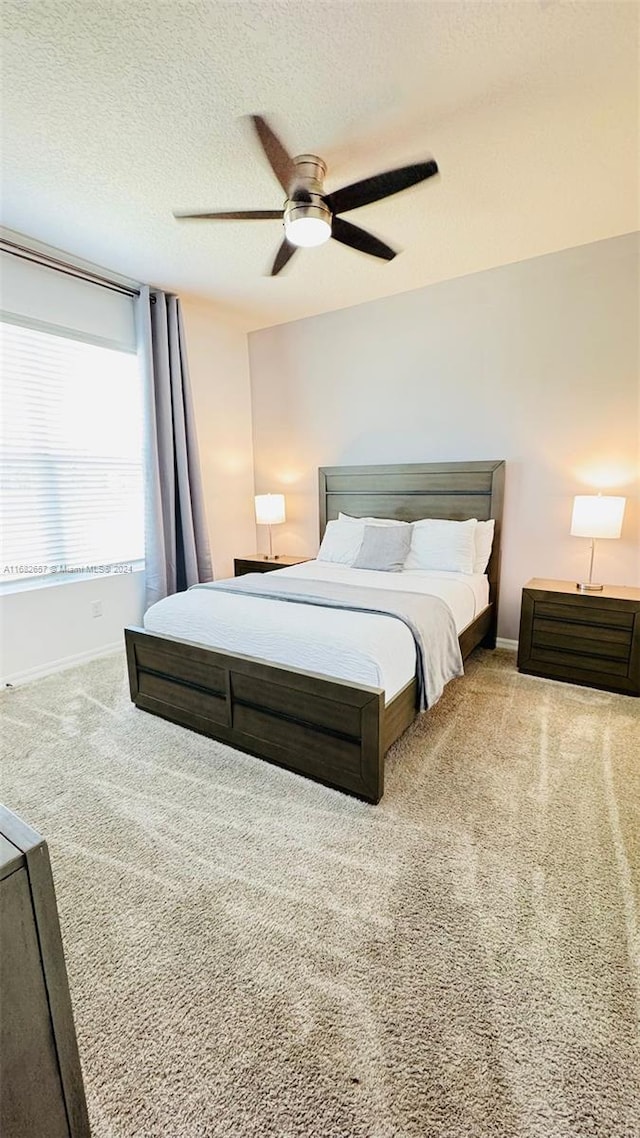 carpeted bedroom with a textured ceiling and ceiling fan