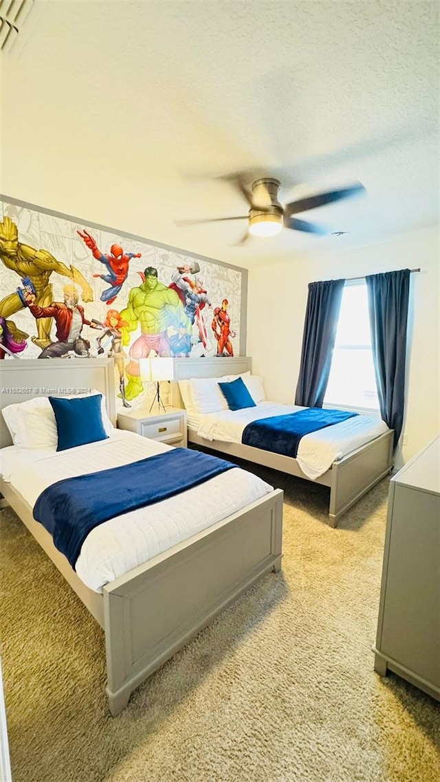 carpeted bedroom featuring a textured ceiling and ceiling fan