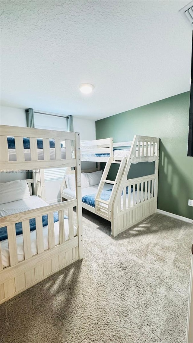 bedroom with a textured ceiling and carpet flooring