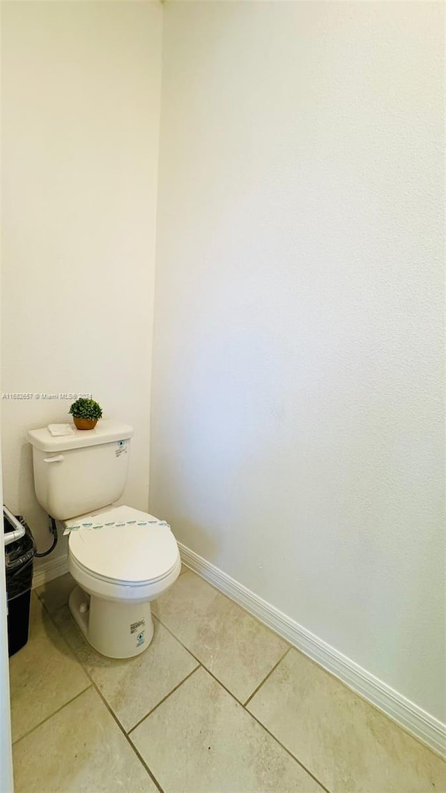 bathroom with toilet and tile patterned flooring