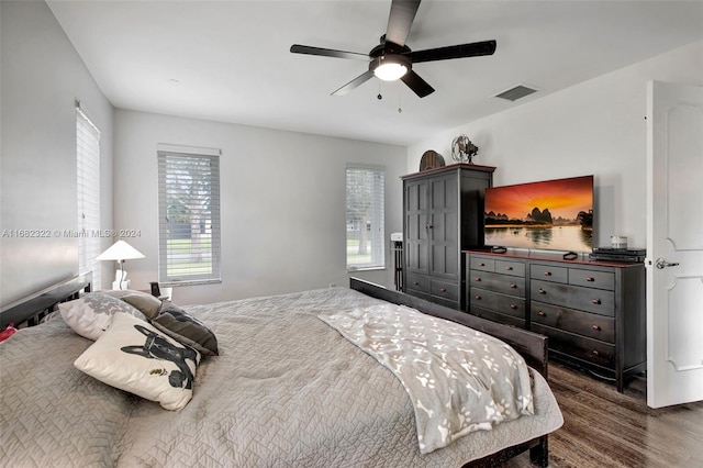 bedroom featuring dark wood-type flooring, ceiling fan, and multiple windows