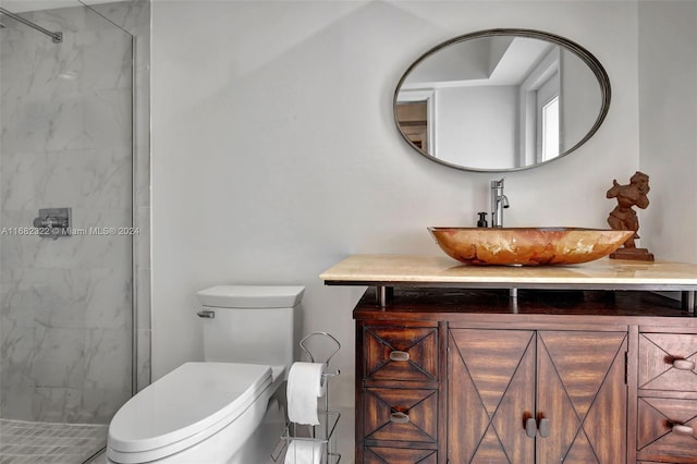 bathroom featuring vanity, toilet, and tiled shower