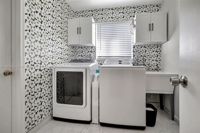 clothes washing area with washing machine and dryer and cabinets