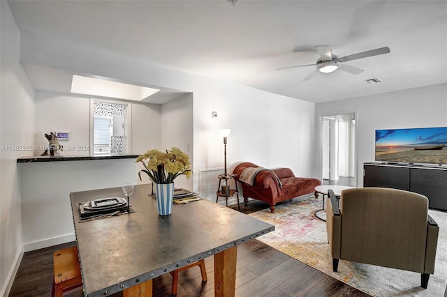 dining area with dark wood-type flooring and ceiling fan