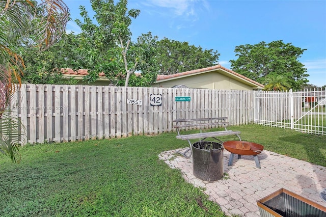 view of yard featuring a patio and an outdoor fire pit