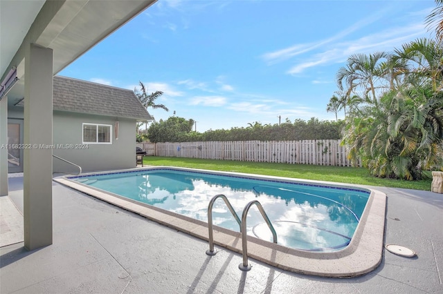 view of swimming pool with a patio area and a lawn