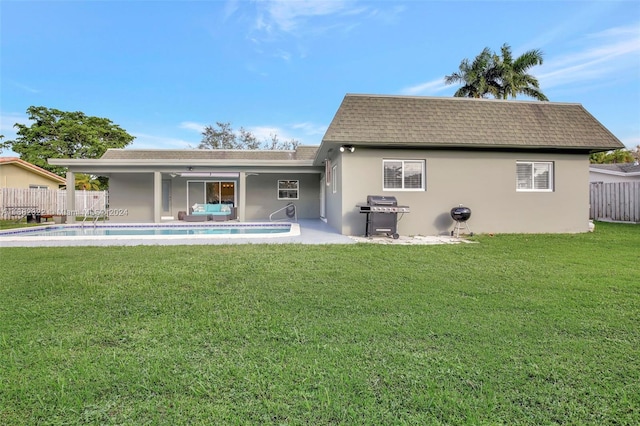 back of house featuring a yard, a patio, and a fenced in pool