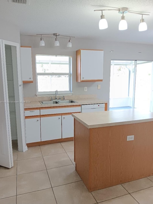 kitchen featuring sink, white cabinets, a textured ceiling, and a healthy amount of sunlight