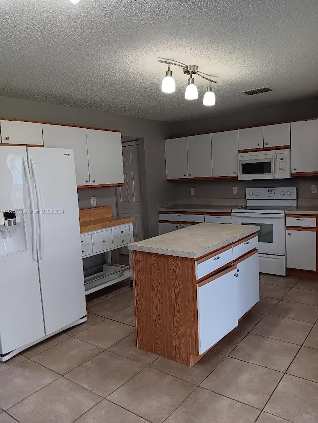 kitchen featuring a textured ceiling, visible vents, white cabinets, and white appliances