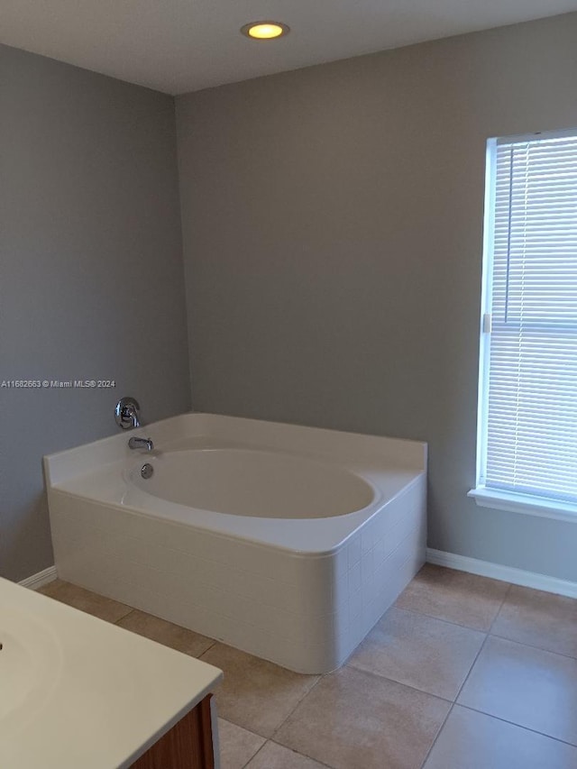 bathroom featuring vanity, tiled tub, and tile patterned flooring