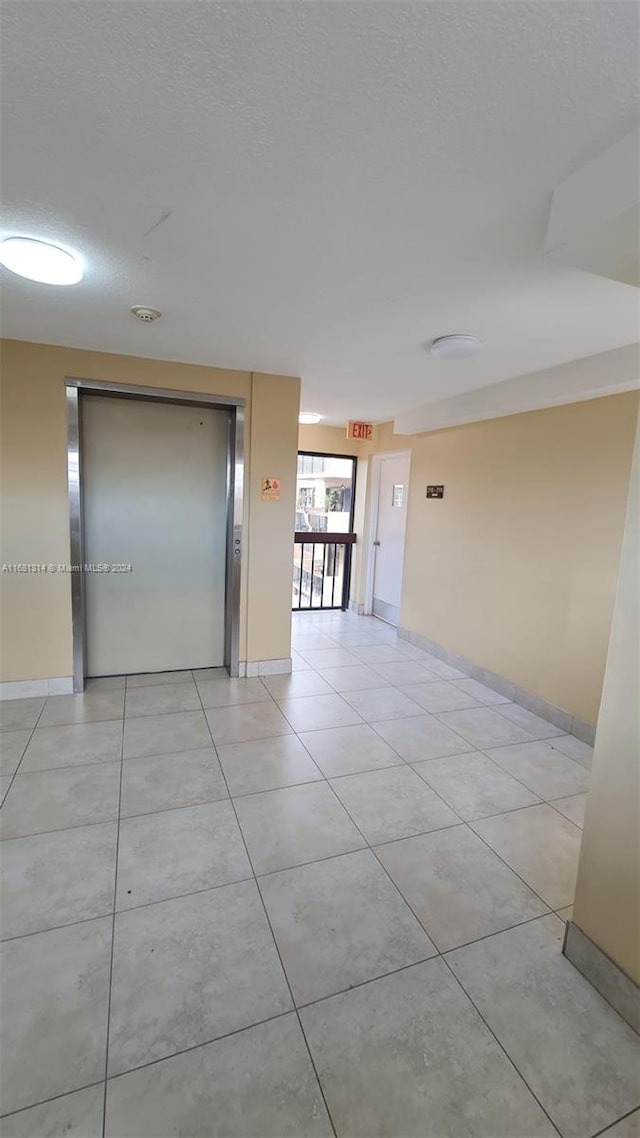 tiled empty room with a textured ceiling