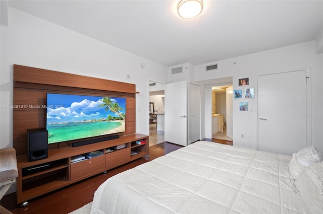 bedroom with ensuite bathroom and wood-type flooring