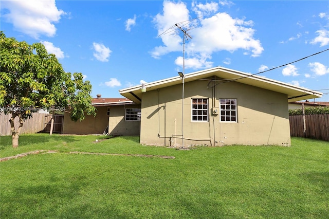 back of property featuring a lawn