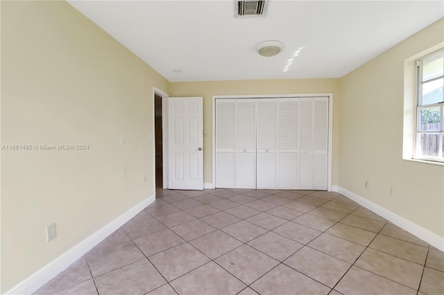 unfurnished bedroom with a closet and light tile patterned flooring