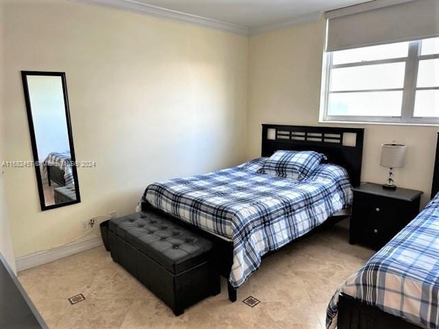 tiled bedroom featuring ornamental molding and baseboards