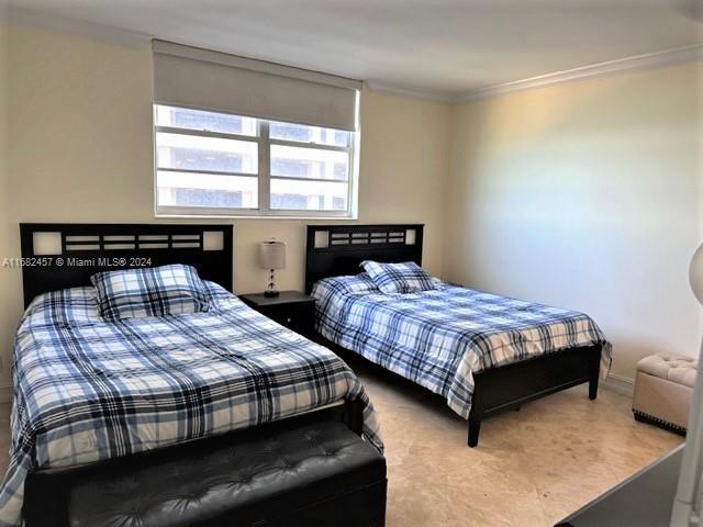 bedroom with crown molding and baseboards