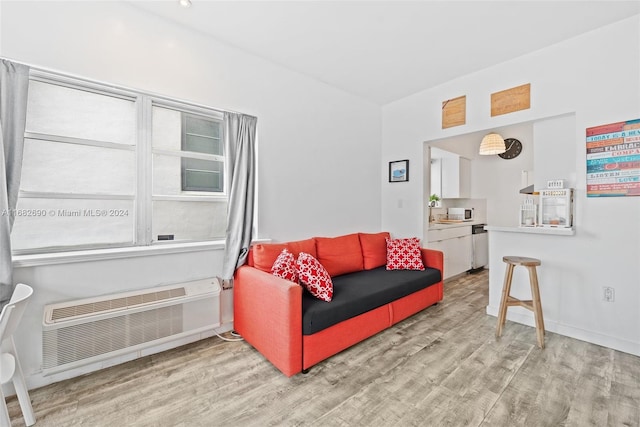 living room featuring an AC wall unit and light hardwood / wood-style flooring