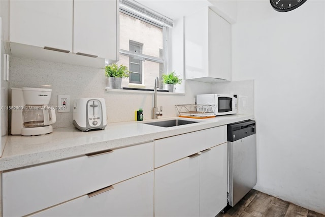 kitchen featuring light stone countertops, stainless steel dishwasher, dark hardwood / wood-style floors, and white cabinets