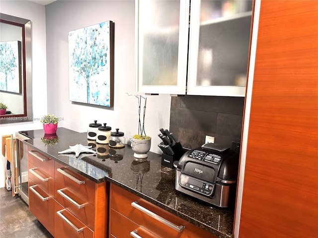 kitchen with decorative backsplash and dark stone counters