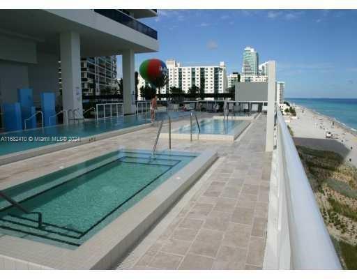 view of pool featuring a patio area and a water view