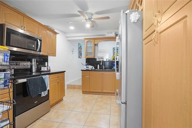 kitchen with sink, appliances with stainless steel finishes, light tile patterned floors, and tasteful backsplash