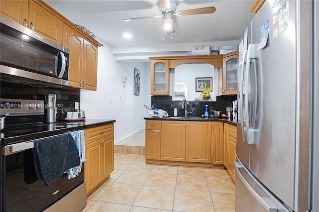 kitchen with appliances with stainless steel finishes, sink, ceiling fan, decorative backsplash, and light tile patterned floors