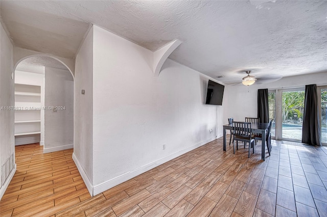 dining space featuring light hardwood / wood-style floors, a textured ceiling, and ceiling fan