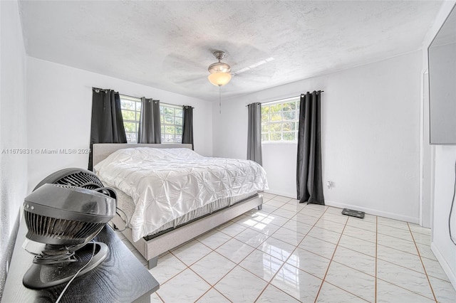 bedroom with multiple windows, a textured ceiling, and ceiling fan