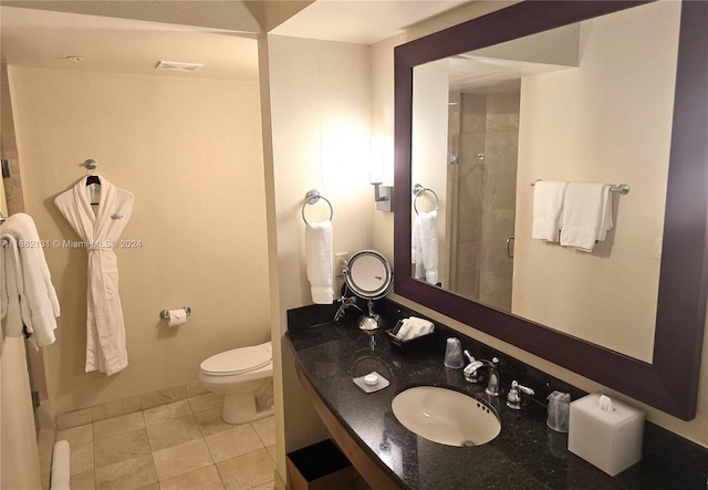 bathroom featuring a shower with door, vanity, toilet, and tile patterned flooring