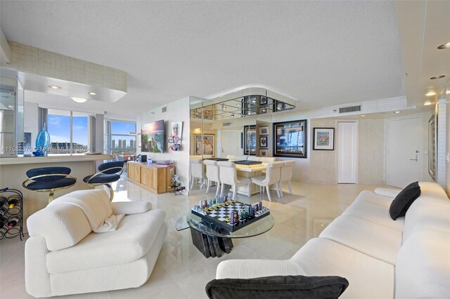 living room with light tile patterned flooring and a textured ceiling