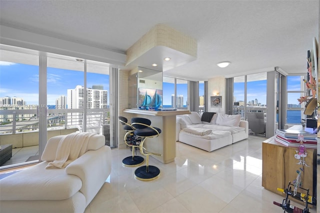 living room with light tile patterned flooring, a textured ceiling, and a wealth of natural light