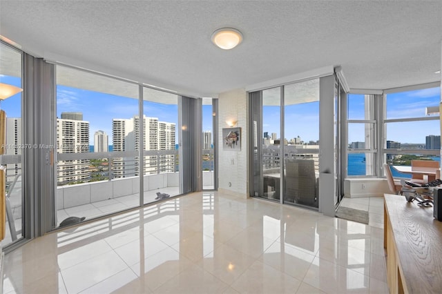 empty room with a wall of windows, light tile patterned floors, and a wealth of natural light