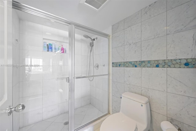 bathroom featuring toilet and a shower with shower door