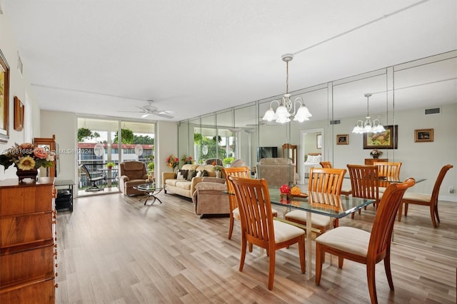 dining space with light hardwood / wood-style flooring and ceiling fan with notable chandelier