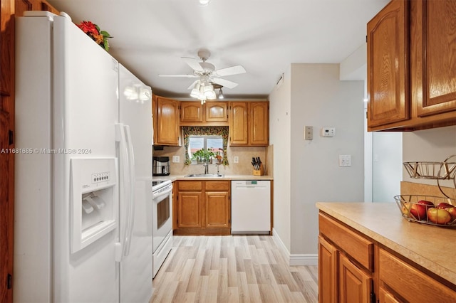 kitchen with white appliances, sink, backsplash, ceiling fan, and light hardwood / wood-style flooring