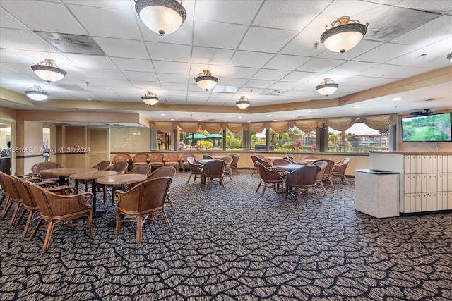 carpeted dining room with a paneled ceiling