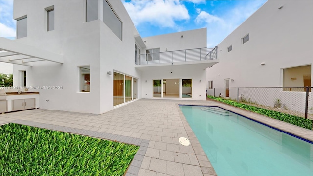 view of swimming pool with sink, area for grilling, and a patio