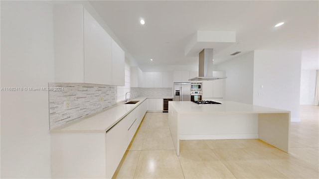 kitchen featuring exhaust hood, a kitchen island, appliances with stainless steel finishes, white cabinetry, and sink